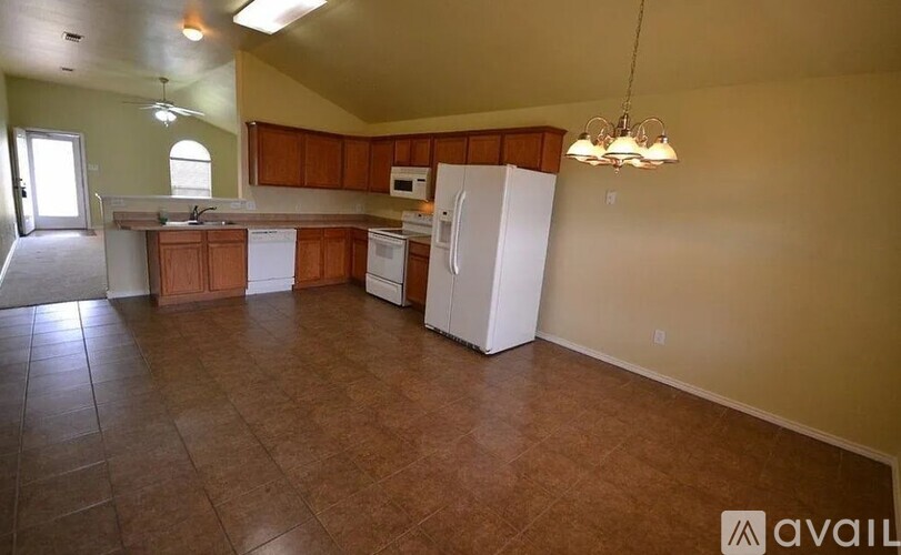 A kitchen with brown floors and white appliances.