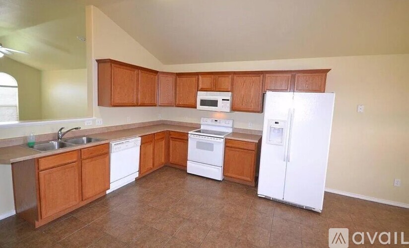 A kitchen with wooden cabinets and white appliances.