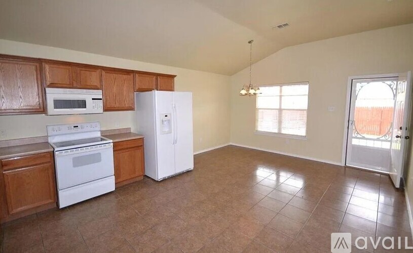 A kitchen with white appliances and wooden cabinets.