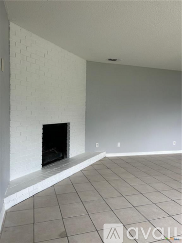 A living room with a fireplace and tiled floor.