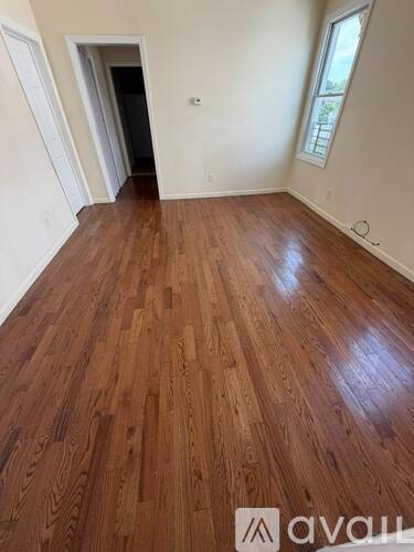 A room with wooden flooring and a window.