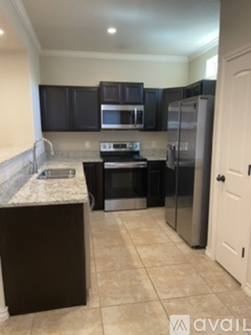 A kitchen with dark brown cabinets and a white door.
