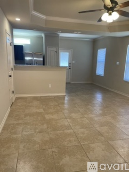 A spacious room with a ceiling fan and tile flooring.