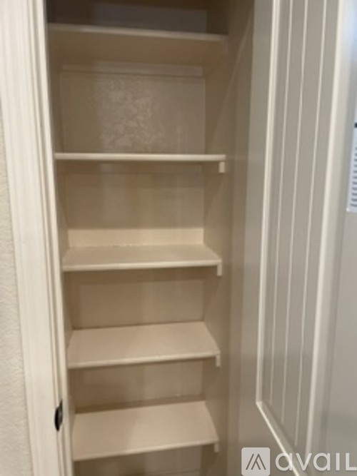 Empty white shelves in a white pantry.
