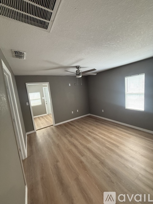 A room with a ceiling fan and light fixture.