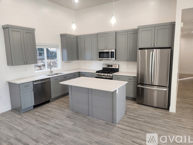 A modern kitchen with a center island and stainless steel appliances.
