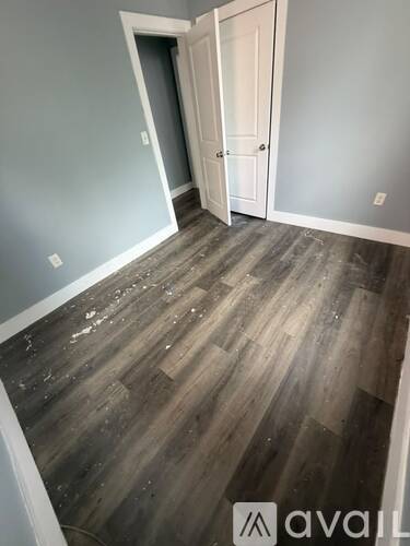 A room with a wooden floor and a white door.
