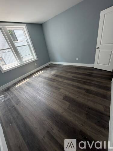 A room with wooden flooring and a window.