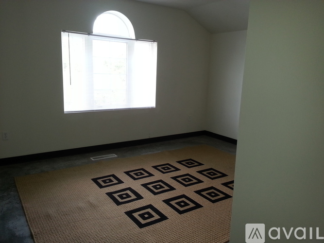 A room with a large window and a patterned carpet.