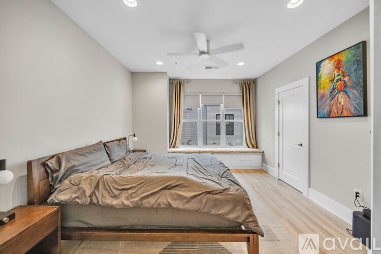 A bedroom with a large bed and a painting on the wall.