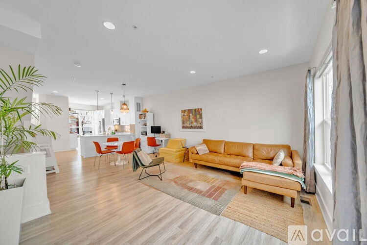 A living room with a couch, chairs, and a rug.