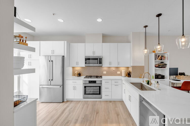A modern kitchen with white cabinets and stainless steel appliances.