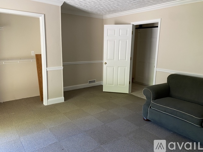 A room with a grey couch and a white door.