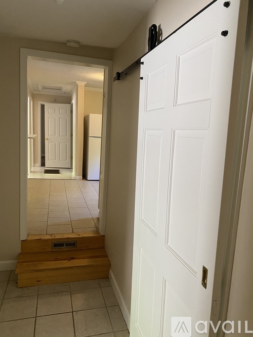 A white door with a black handle is on the right side of the image.