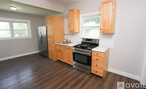 A kitchen with wooden cabinets and a black refrigerator.