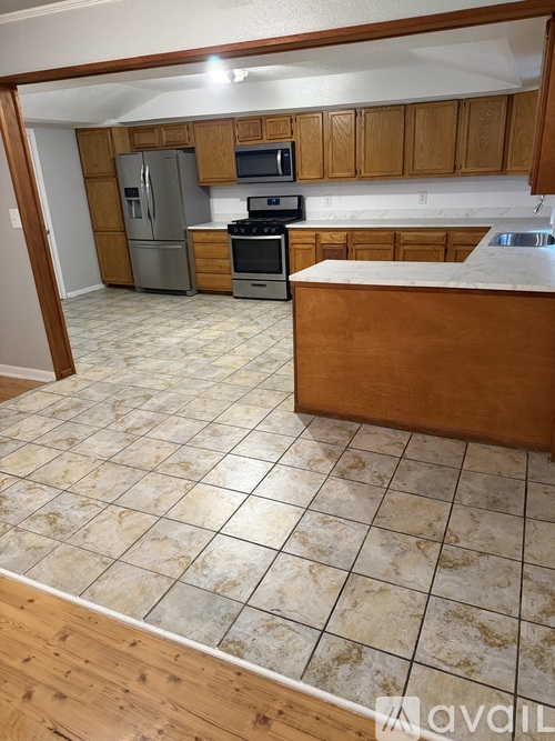 A kitchen with wooden cabinets and a tile floor.