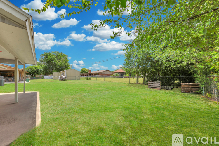 A backyard with a playground and a fence.