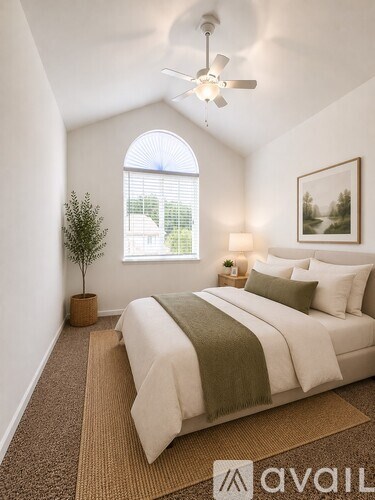 A bedroom with a large bed and a ceiling fan.