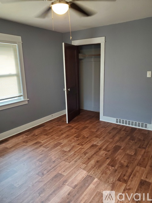A room with wooden flooring and a ceiling fan.