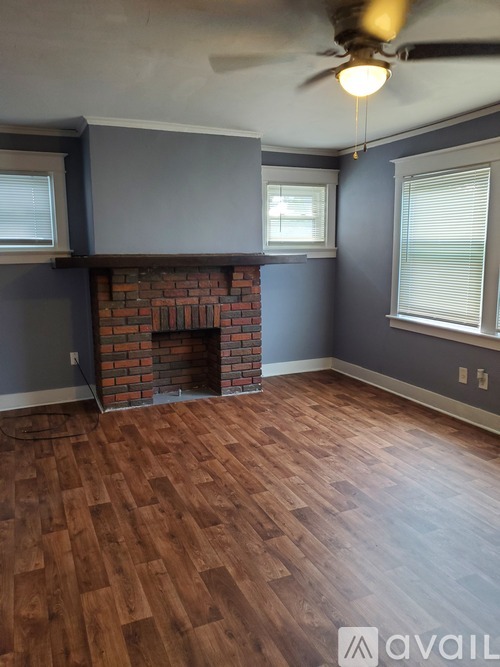 A room with a fireplace and wood flooring.
