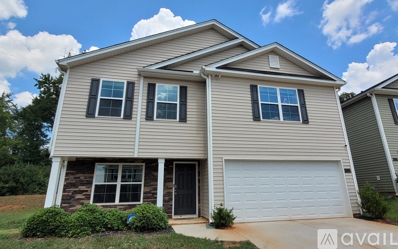 A two-story house with a garage is available for sale.