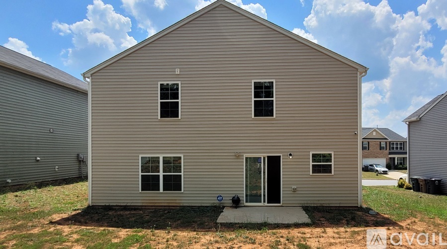 A two-story house with a grey exterior and a black door.