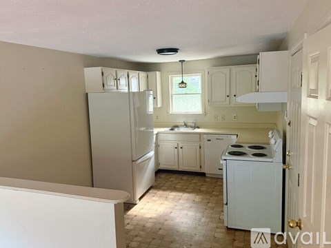 A kitchen with white appliances and cabinets is available for rent.