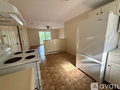 A kitchen with a white stove top oven and a white refrigerator.