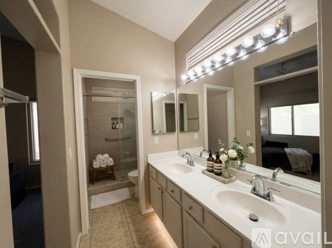 A bathroom with a vanity, a mirror, and a shower.