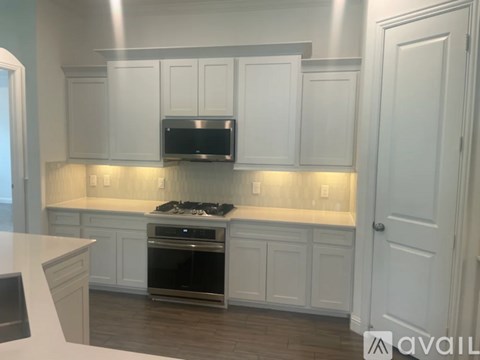 A kitchen with white cabinets and a stainless steel oven.