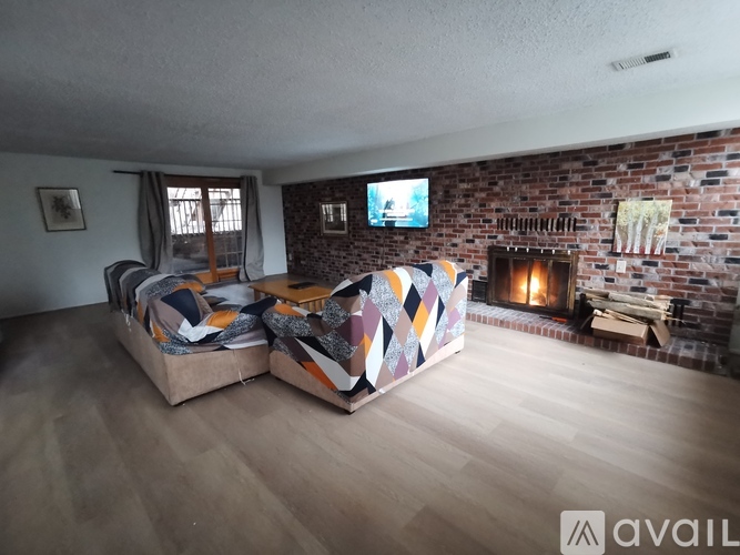 A living room with a brick wall and a fireplace.