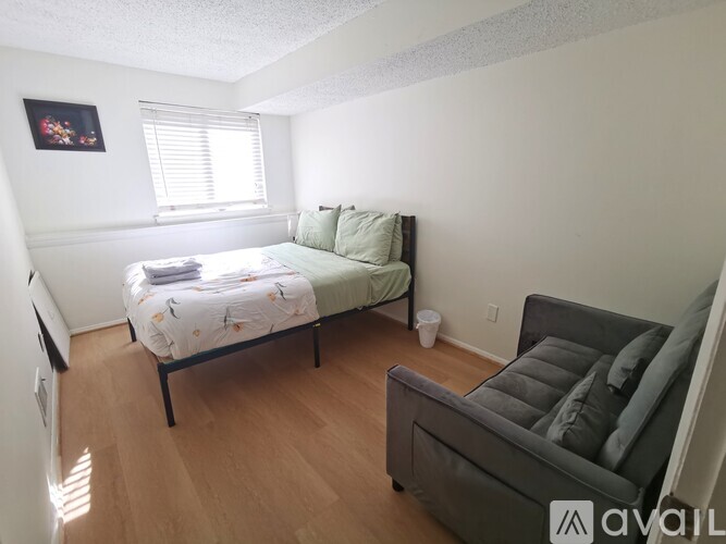 A bedroom with a bed and a couch.