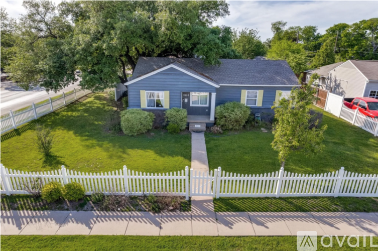 A blue house with a white picket fence in front.