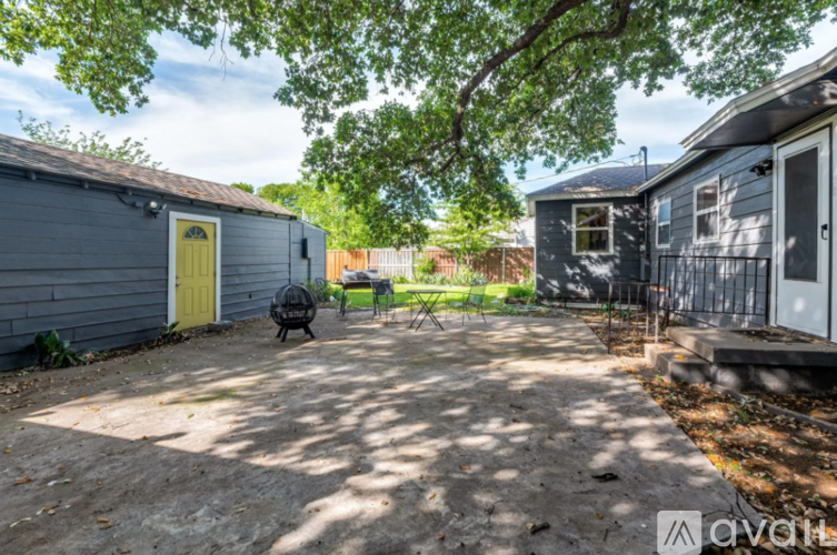 A backyard with a small tree, a fence, and a small shed.