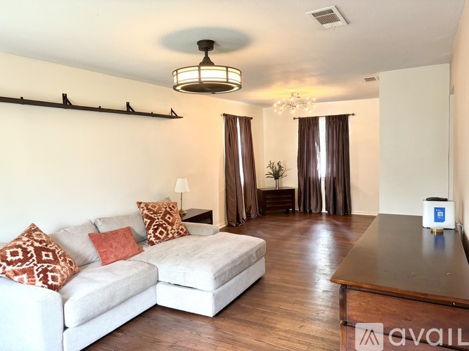 A living room with a white couch and a wooden table.