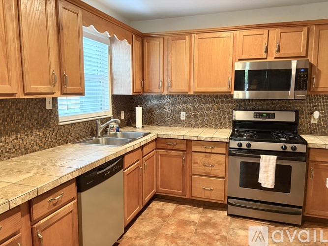 A kitchen with wooden cabinets and a black oven.