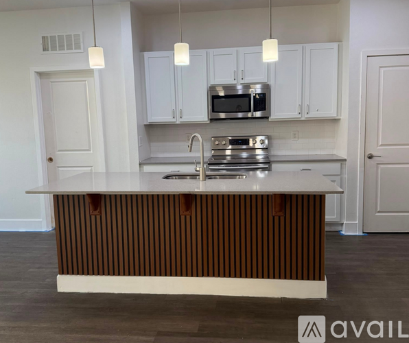 A kitchen with white cabinets and a brown striped island.