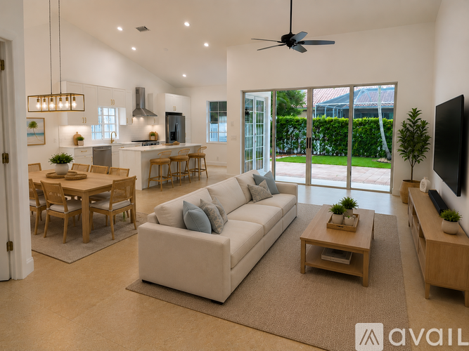 A spacious living room with a white sofa, wooden coffee table, and a television on the right side.