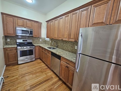 A kitchen with wooden cabinets and a stainless steel refrigerator.