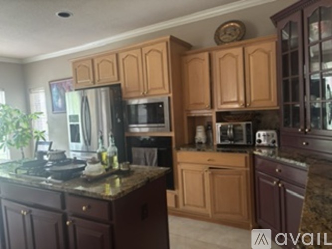 A kitchen with wooden cabinets and granite countertops.