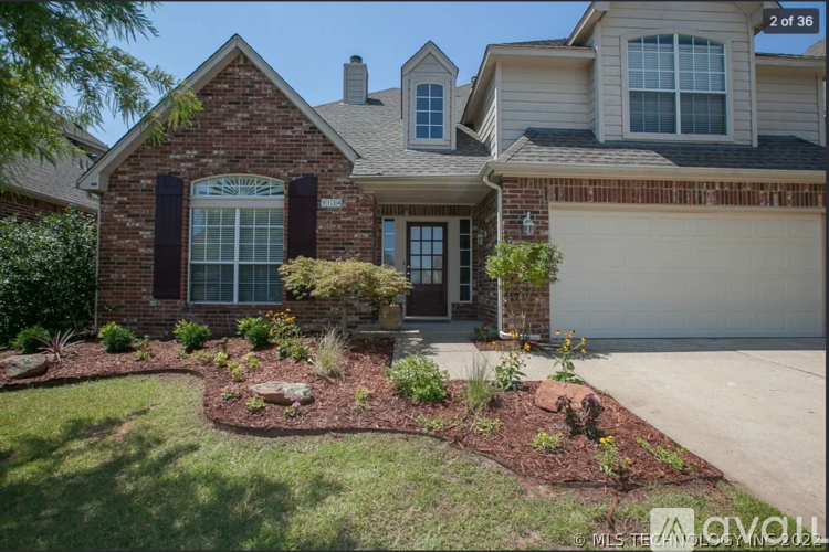 A house with a brick facade and a landscaped front yard.