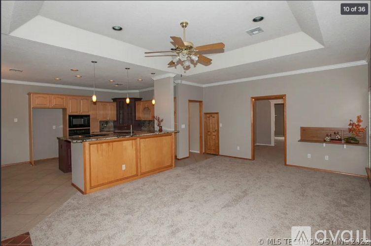 A spacious living room with a kitchen area in the background.