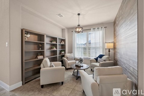 A living room with a large window, a sofa set, and a coffee table.