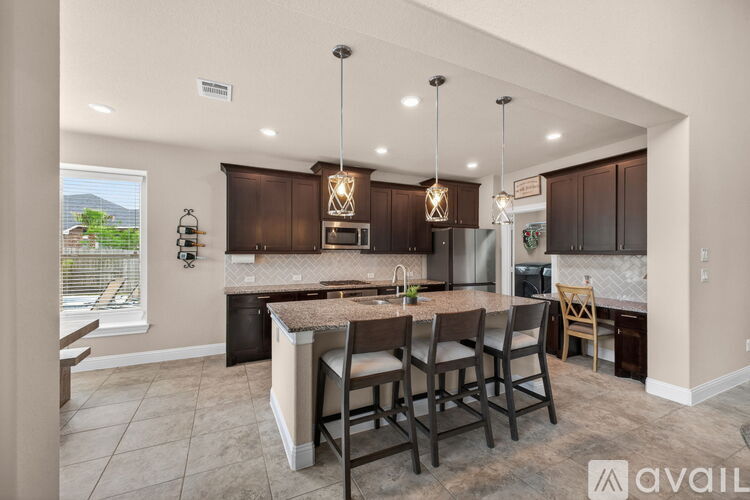 A modern kitchen with dark brown cabinets and a central island.