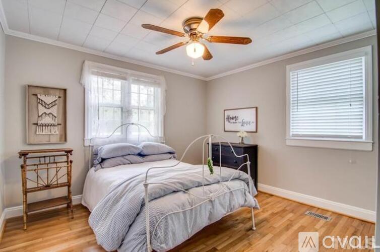 A bedroom with a bed, nightstand, and a ceiling fan.