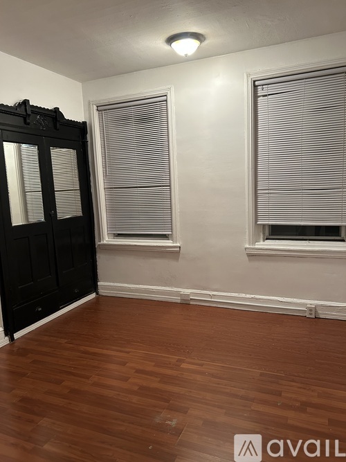 A room with wooden floors and a black door.