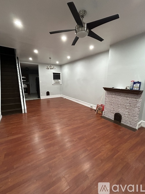 A room with a fireplace and wood flooring.