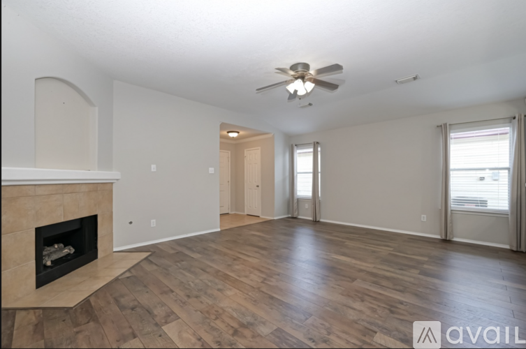 A spacious living room with a fireplace and hardwood floors.