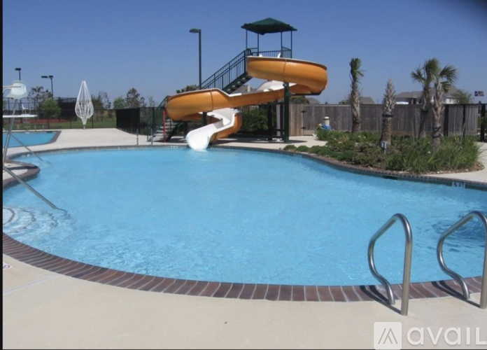 A pool with a slide and a lifeguard tower.