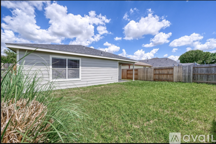 A house with a fence and a grassy yard.
